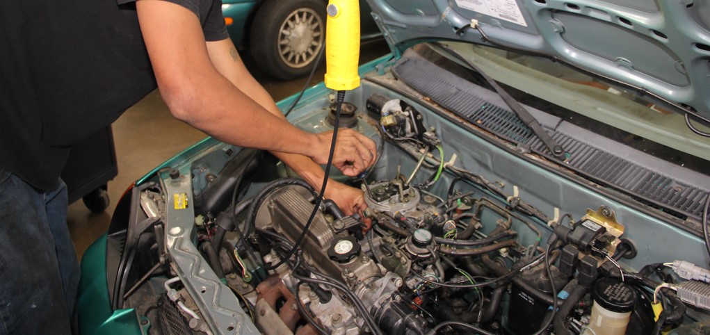 Student working on automobile engine.