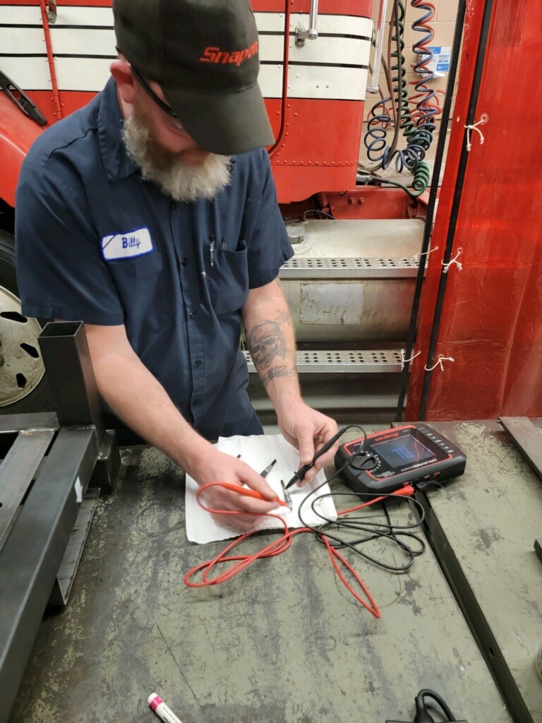 Student testing part with multimeter