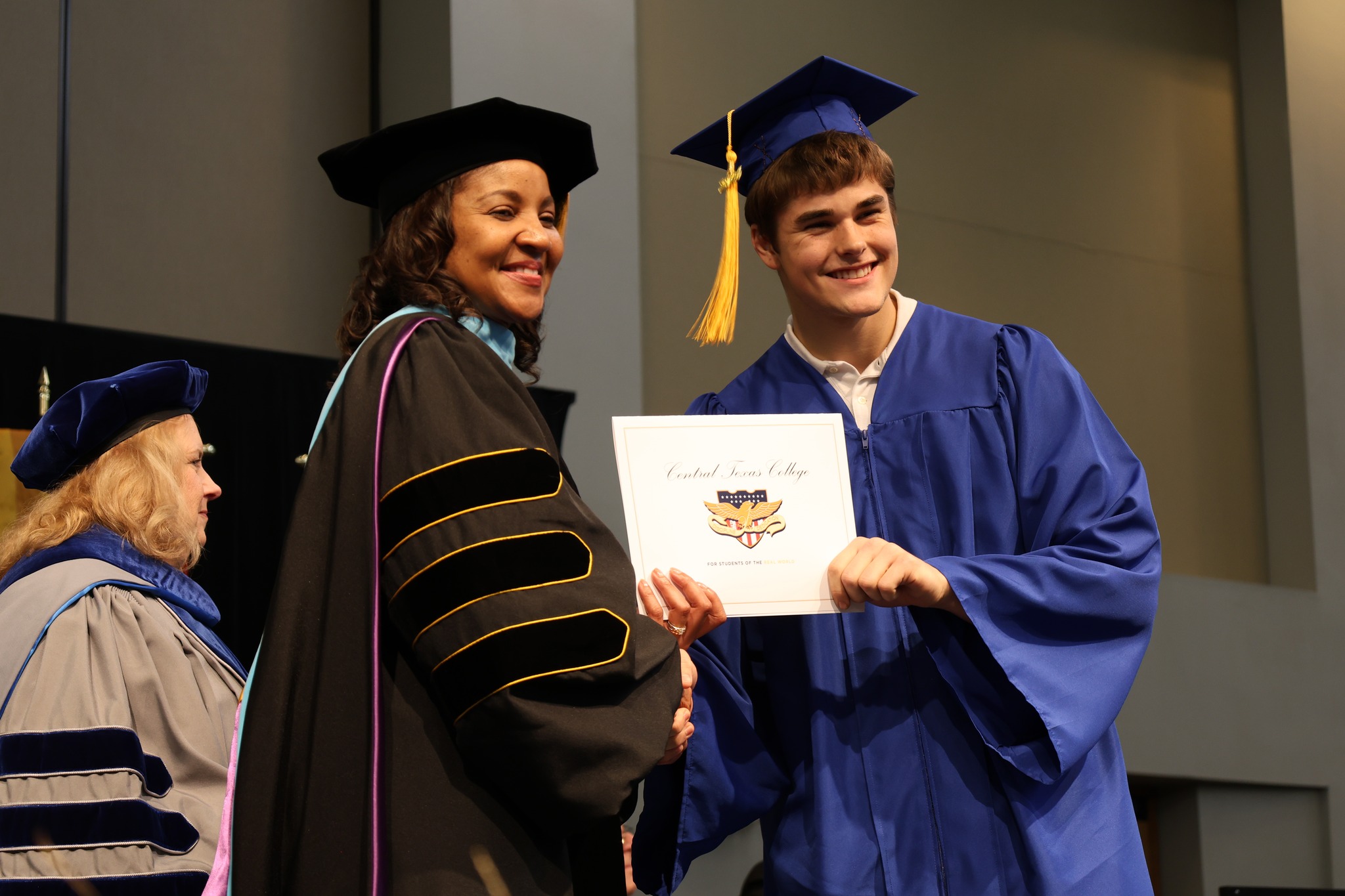 Dr. Michele J. Carter presenting a graduating student their degree.